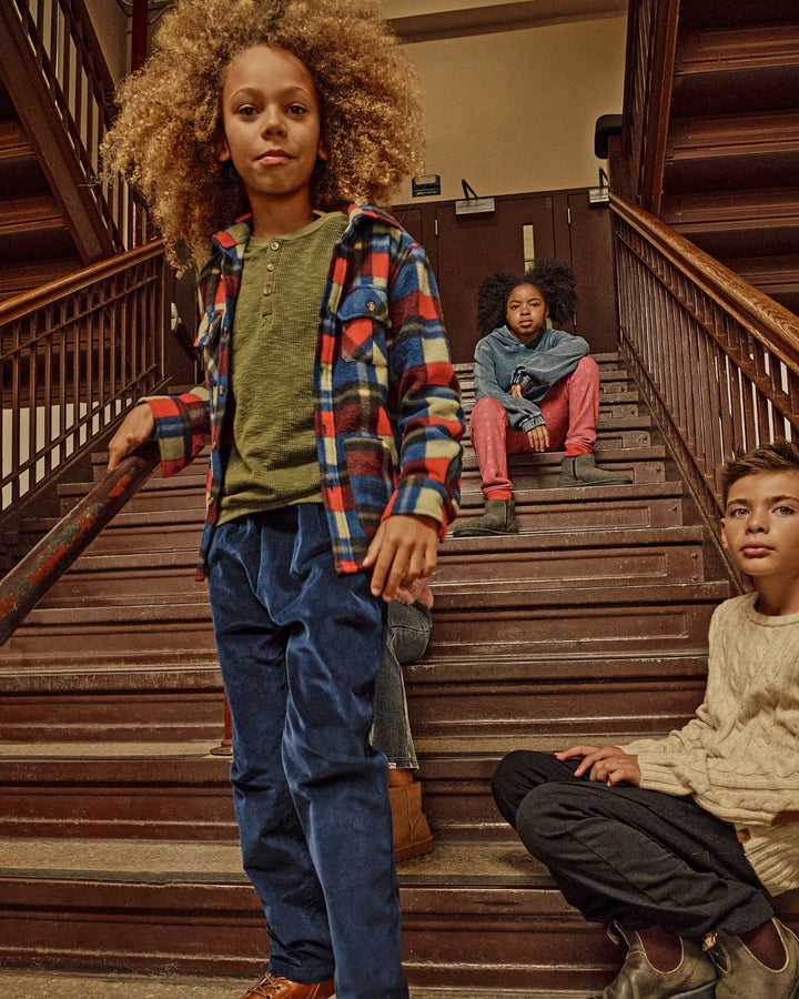 Children standing on wooden stairs in a building interior