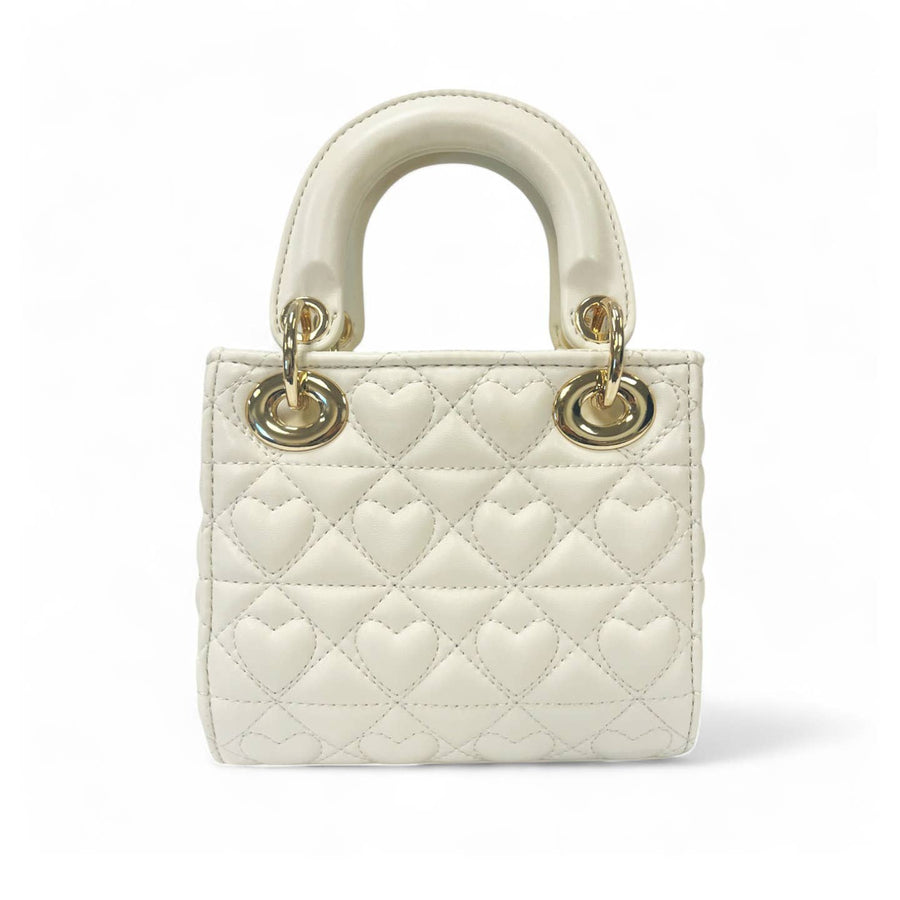 White quilted handbag with gold hardware on a white background