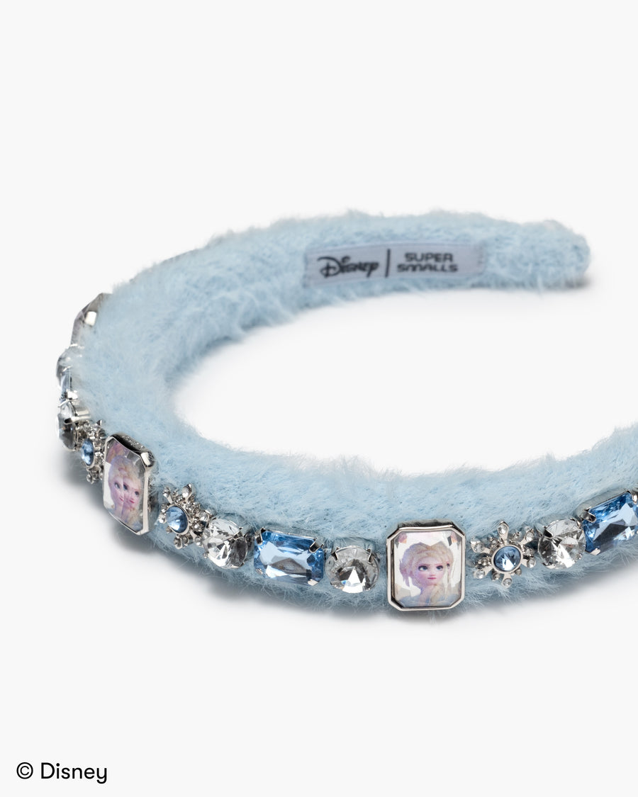 Light blue headband with Frozen character charms and crystals on a white background, featuring Disney branding.