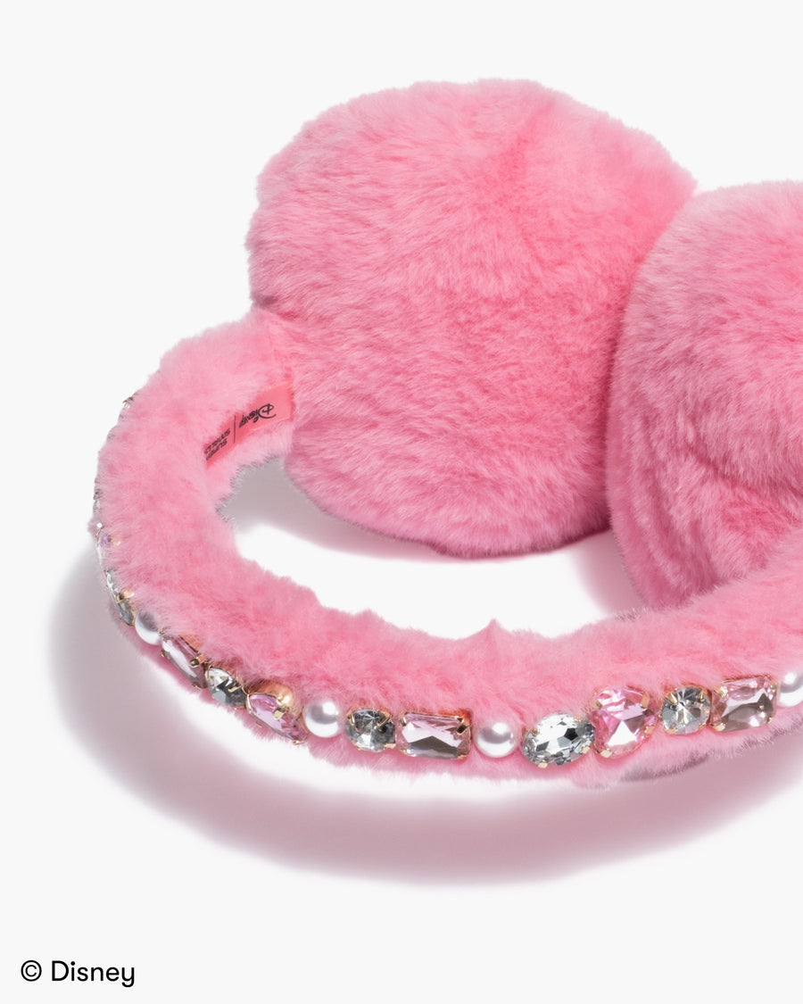 Pink fluffy earmuffs with decorative elements on a white background, featuring Disney branding.