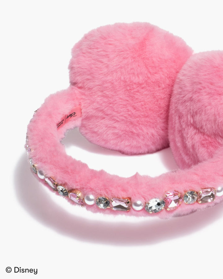Pink fluffy earmuffs with decorative elements on a white background, featuring Disney branding.