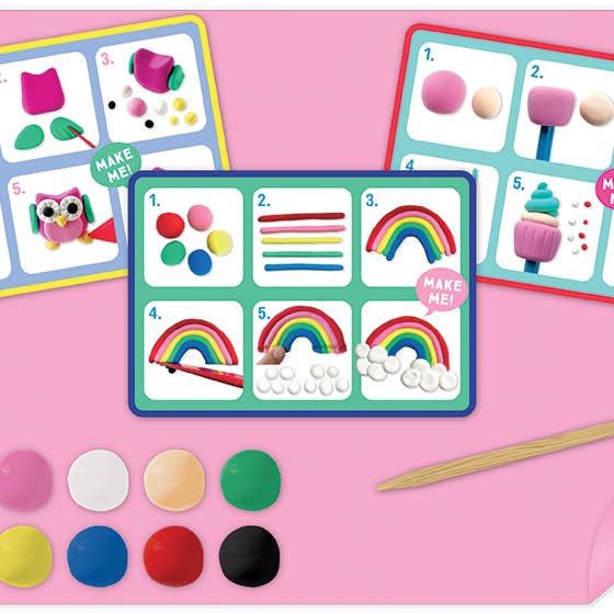 Colorful clay modeling kit with templates and supplies on a pink background
