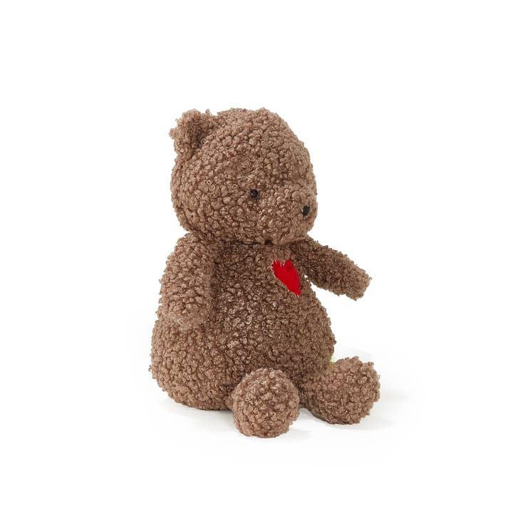 side view of brown teddy bear with red heart patch on his chest