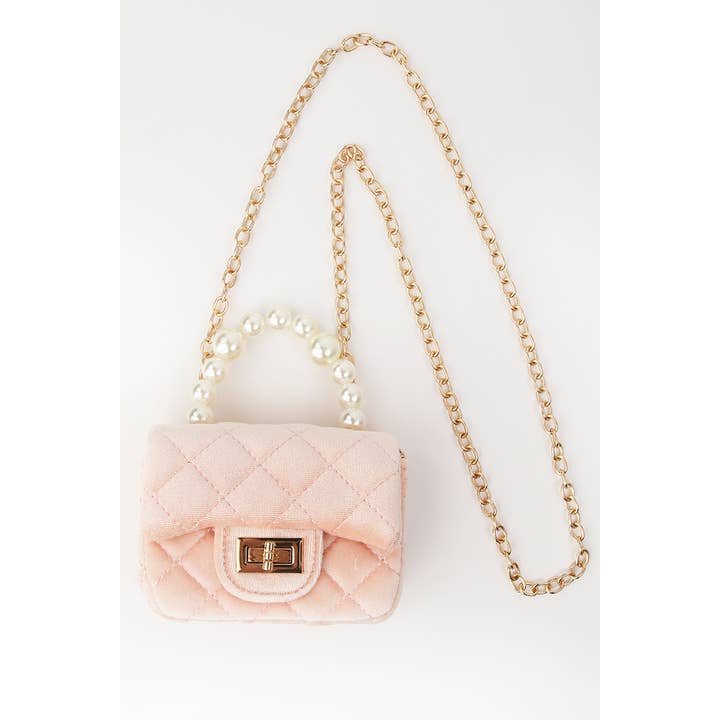 light pink quiled velvet handbag with pearl handle and detachable gold chain. 