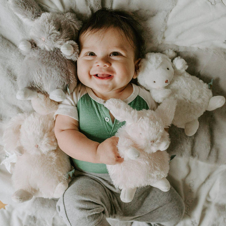 baby surrounded by the wee stuffed animals. 