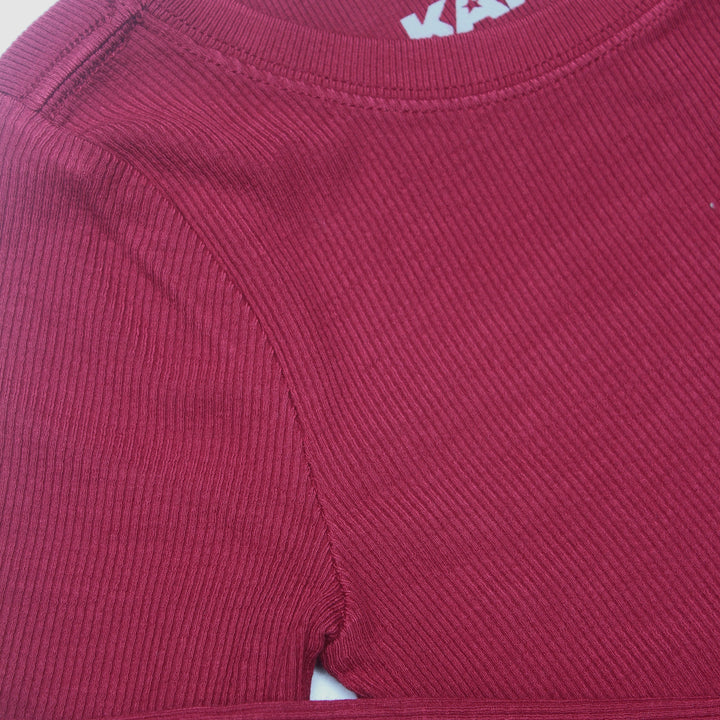 Close-up of a maroon shirt with a brand logo on the collar.