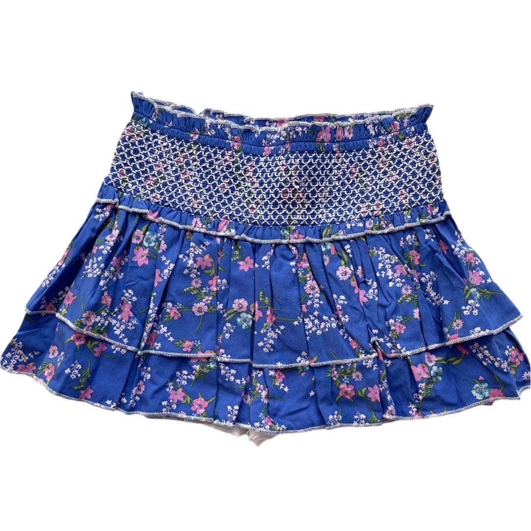 bright blue skort with white stitching at the band of the skirt with pink and white flowers all over it 
