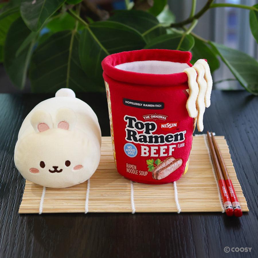 plush bunny sitting next to a ramen cup in Beef flavor. 