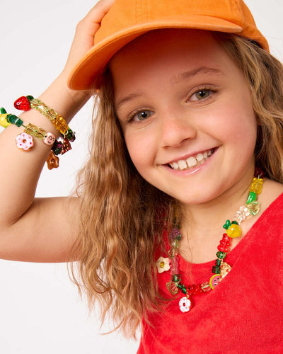 little girl wearing jewelery made from the beads and charms in the kit. 