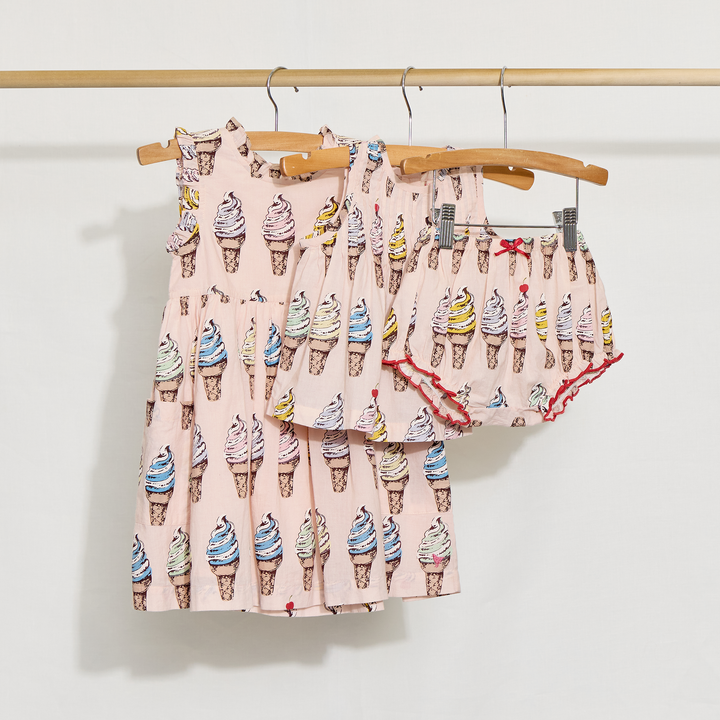 Children's dress and 2 piece set with ice cream cone pattern on a wooden hanger against a white background