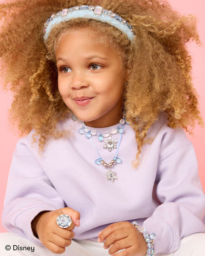 little girl modeling a necklace, ring and bracelets made with the Elsa bead kit 