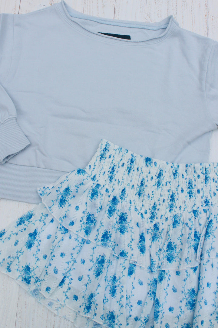 baby blue sweatshirt wide neckline and coordinating white skirt with blue floral design on the skirt. 