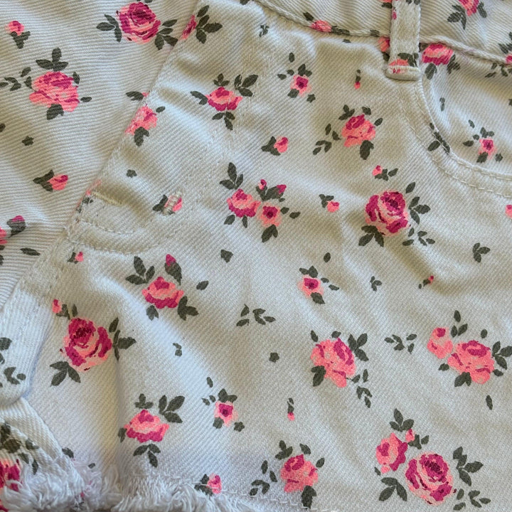 close up of the print on white twill and tiny pink roses and rosebuds all over. 