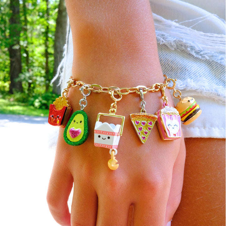 Bracelet with colorful charms on a wrist against a blurred outdoor background