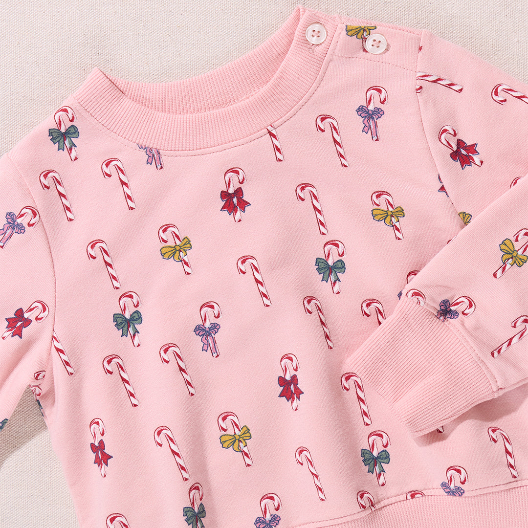 Pink sweatshirt with candy cane and bow pattern on a light background