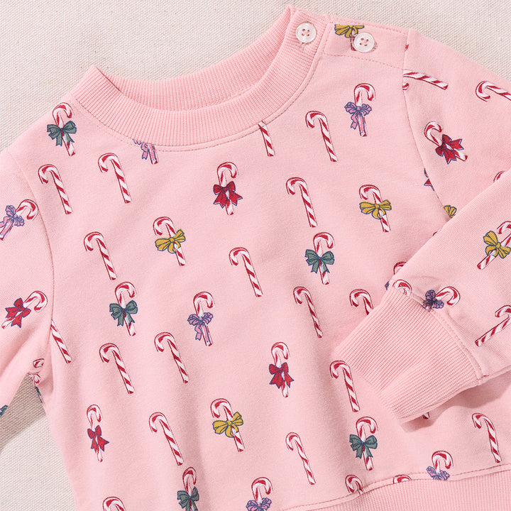 Pink sweatshirt with candy cane and bow pattern on a light background