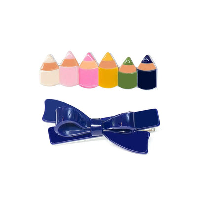 Set of 2 hair clips for girls. One Clip is a colorful pencils hair clip and the other is a blue bow hair clip. Clips are by Lilies and Roses NY 