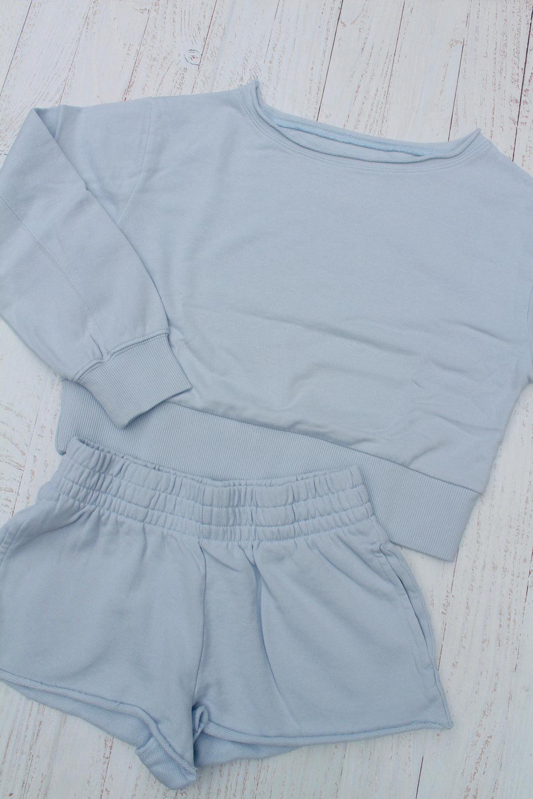 baby blue off the shoulder sweatshirt with matching shorts, elastic waistband at shorts and bottom of sweatshirt. 