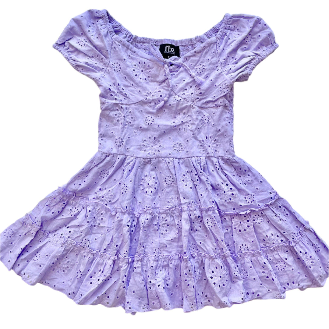 lavender eyelet dress with capsleeve and slight tie at the neckline. the skirt is full and has slight ruffles throughout the skirt. 