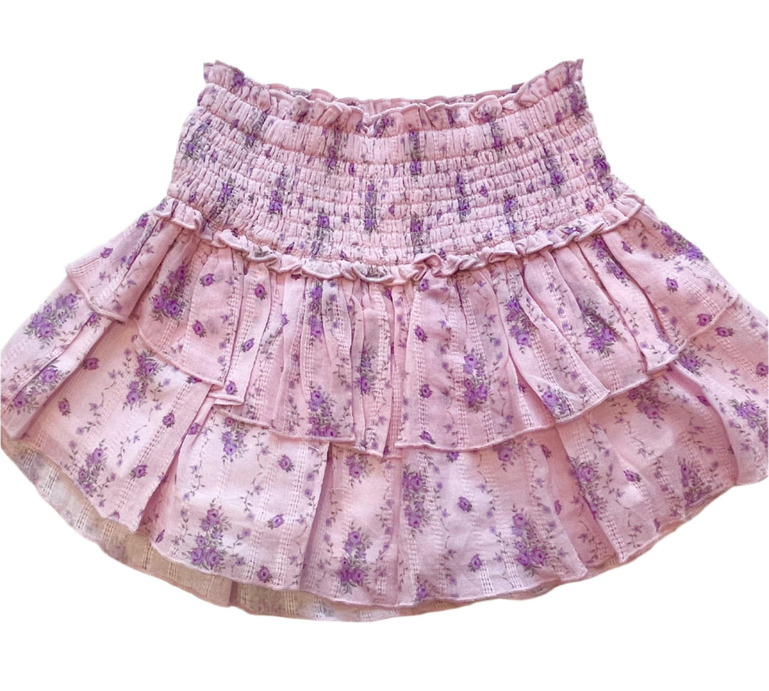 lavender skirt with smocking at the top and layers of printed fabric below smocking. lavender base with purple flowers cascading down the skirt. 