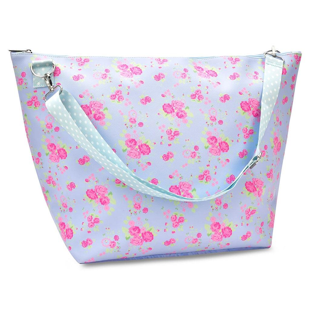 blue floral weekender bag. pink flowers and blue base. blue polka dot chest strap. 
