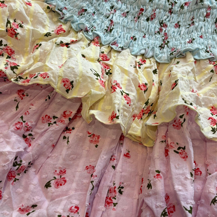 close of up of the colors and pattern on the skirt. Pastel colors: Blue, yellow and pink with tiny roses. 