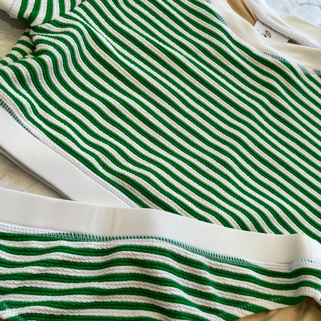 green and white striped bathing suit with white trim at the border. close up of the textured look on this bathig suit. 
