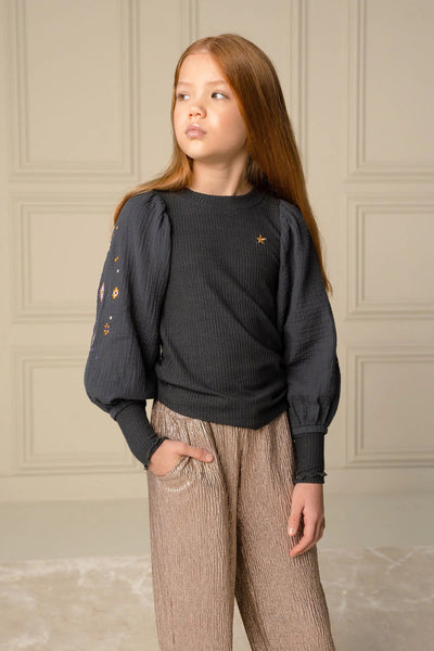 Girl modeling the Fenya Glitter Wide Leg Pant from Like Flo. She is showing there is a pocket detail.