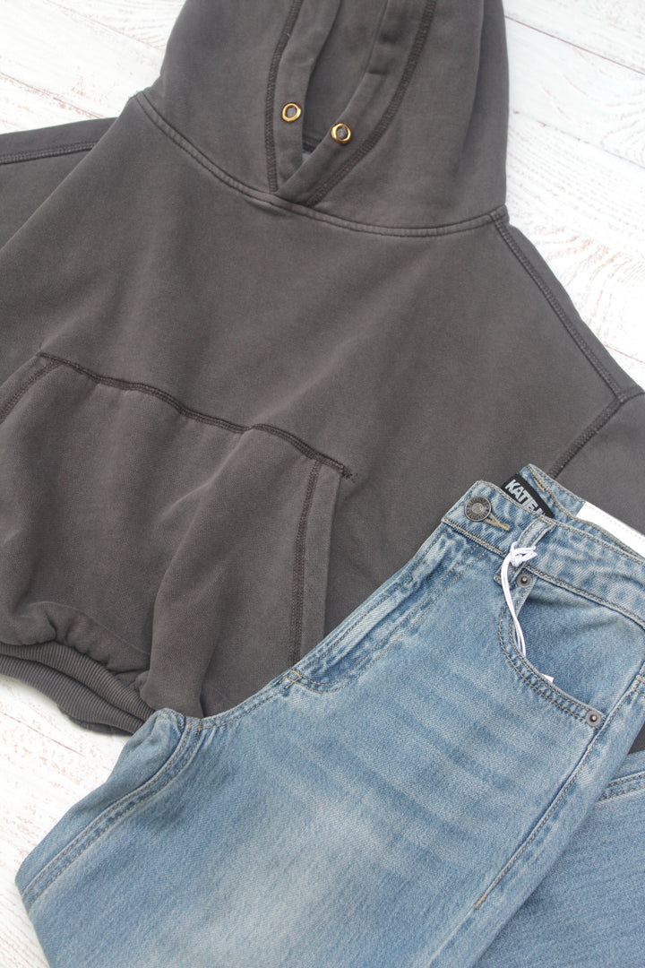 Gray hoodie and blue jeans on a white surface