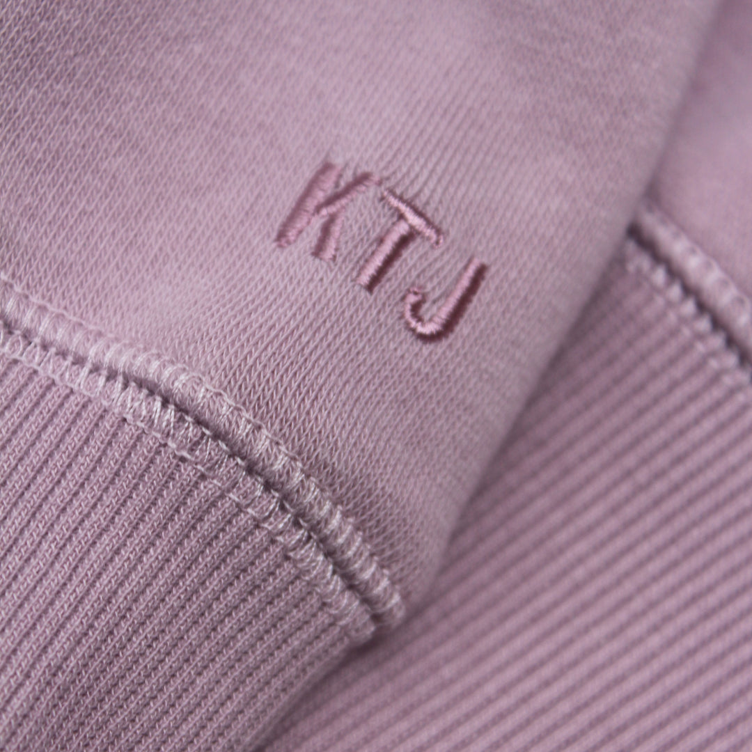 Close-up of a purple fabric with 'KTJ' embroidered on it