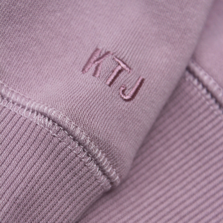 Close-up of a purple fabric with 'KTJ' embroidered on it