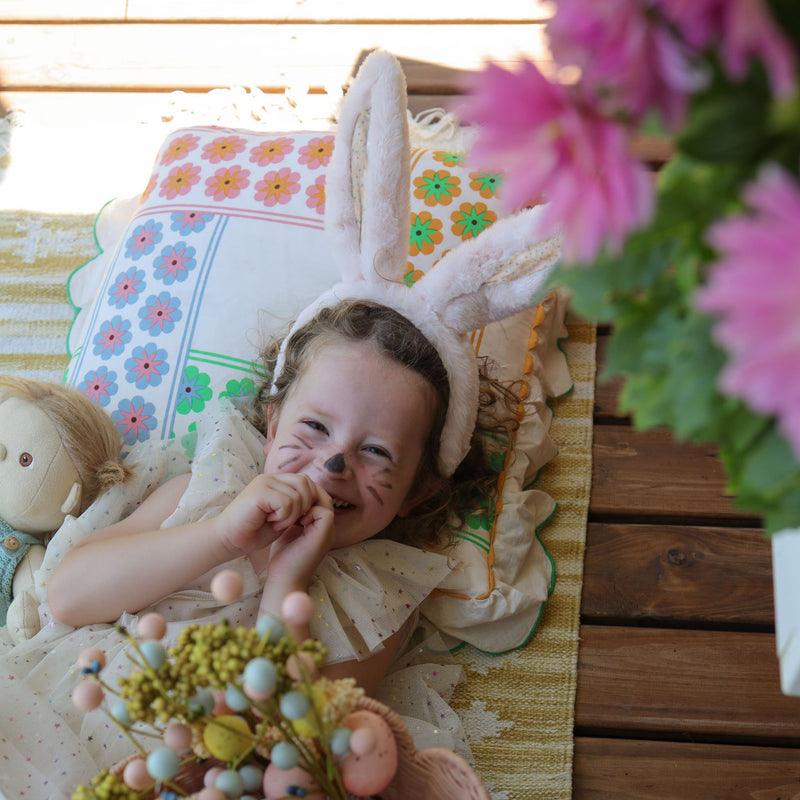little girl giggling with pink fluffy bunny ears on 
