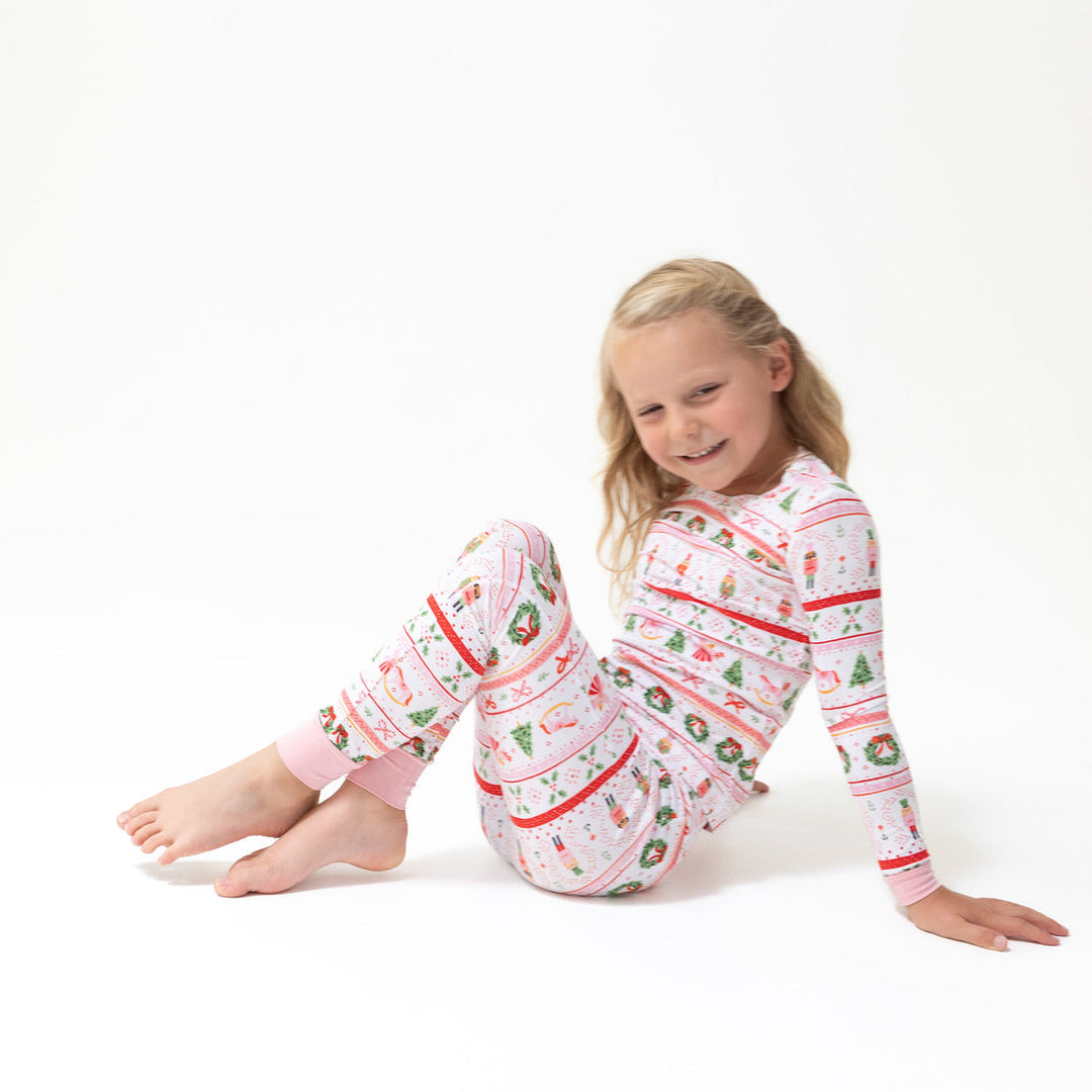 Young girl wearing a festive pajama set with a white background
