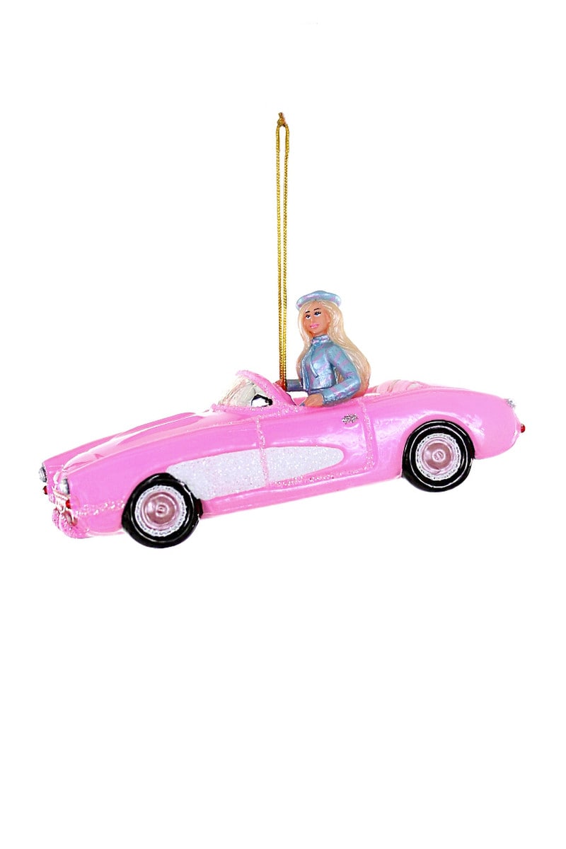 barbie driving a pink corvette in a blue metallic outfit