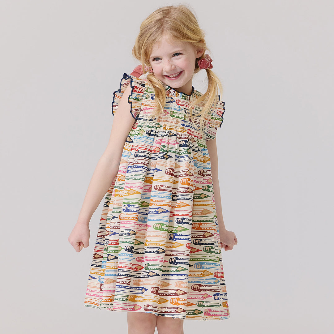 Young girl wearing a colorful dress with a pencil pattern of vintage signs 