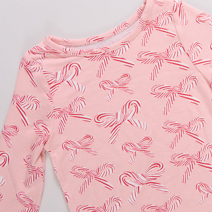 Pink long-sleeve shirt with candy cane pattern on a light gray background