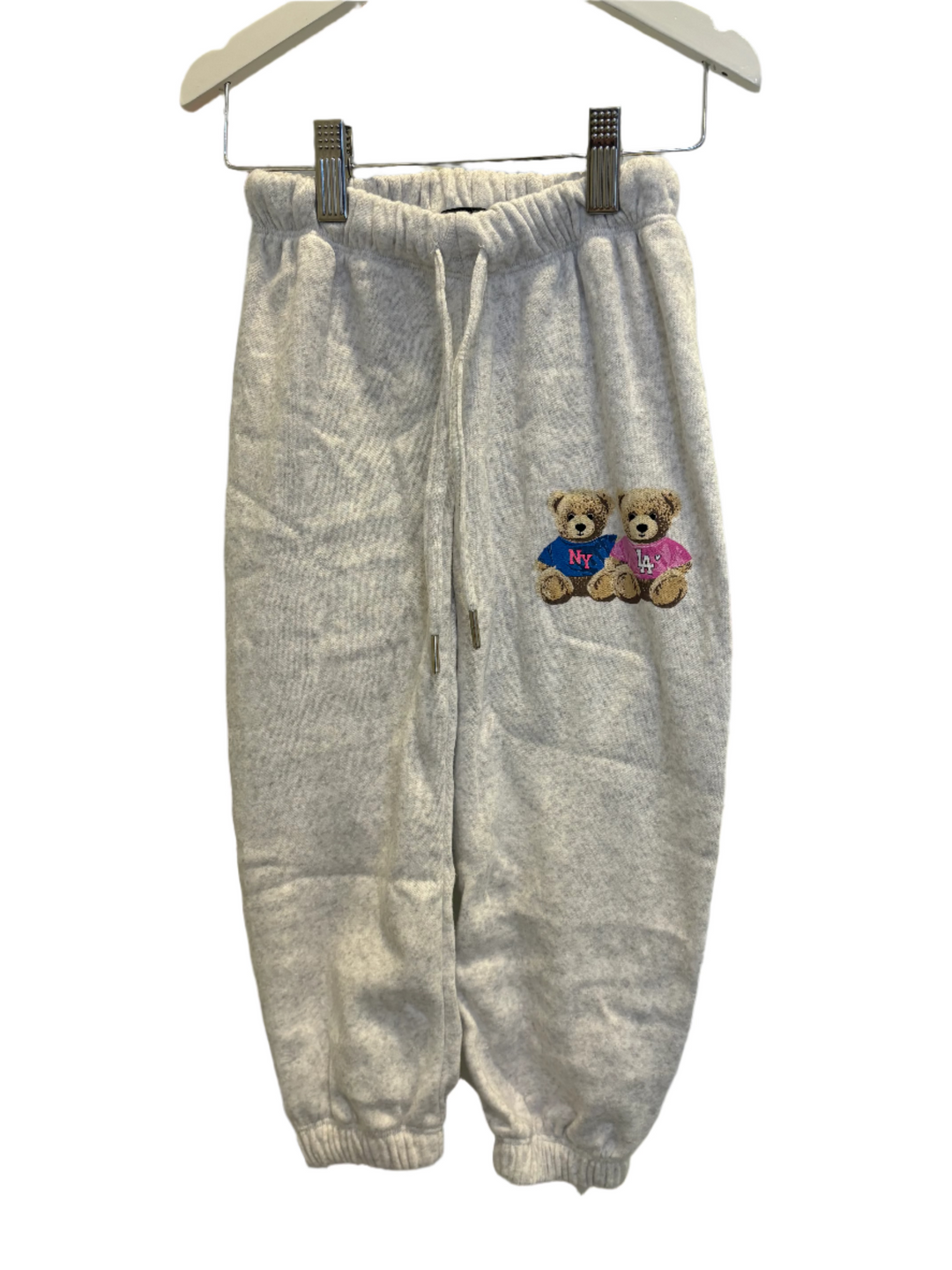 gray sweatpants with two teddy bears on one leg, one teddy bear wearing a pink tee and the other wearing a blue tee. 