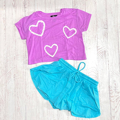 picture of the aqua shorts and a purple shirt that pairs back to these shorts as an outfit option. 