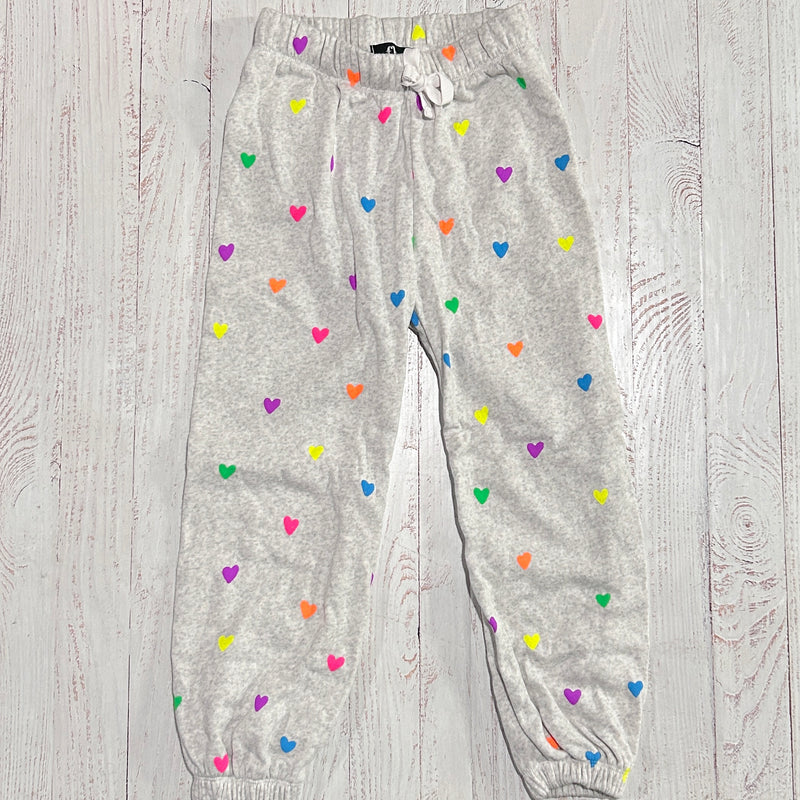 grey sweatpants with all over multi color neon hearts. elastic waist and drawstring. 