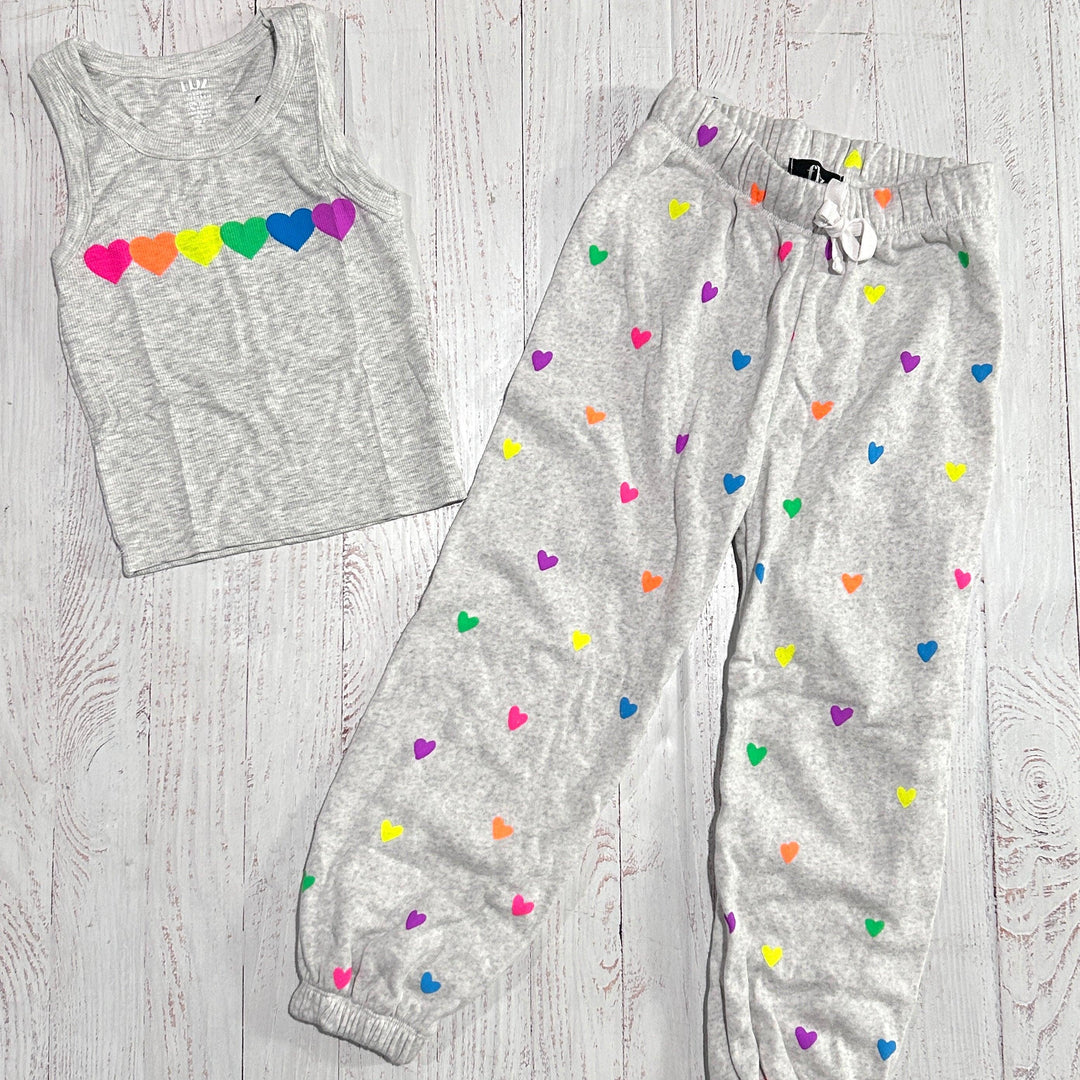 grey tank with neon hearts across the chest and grey joggers with small neon hearts all over the pants
