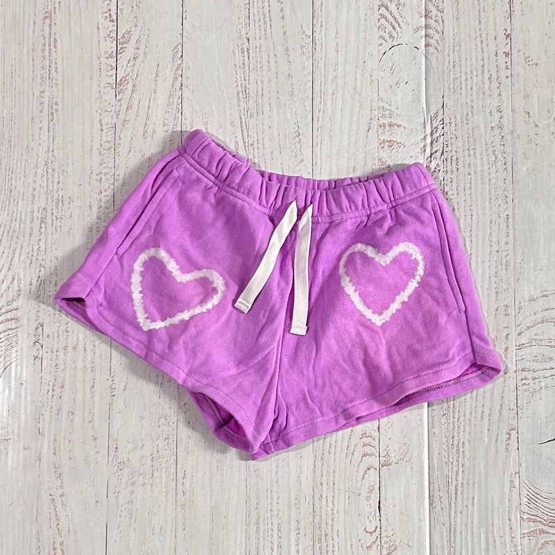 neon purple drawstring shorts. each side of the shorts have a white tie dye heart on it. 