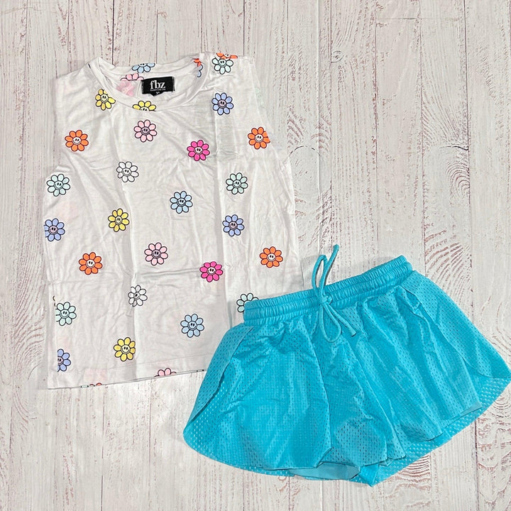 white sleeveless tank with multicolored daisies with smiley faces in the center of it.  and coordinating blue mesh shorts 