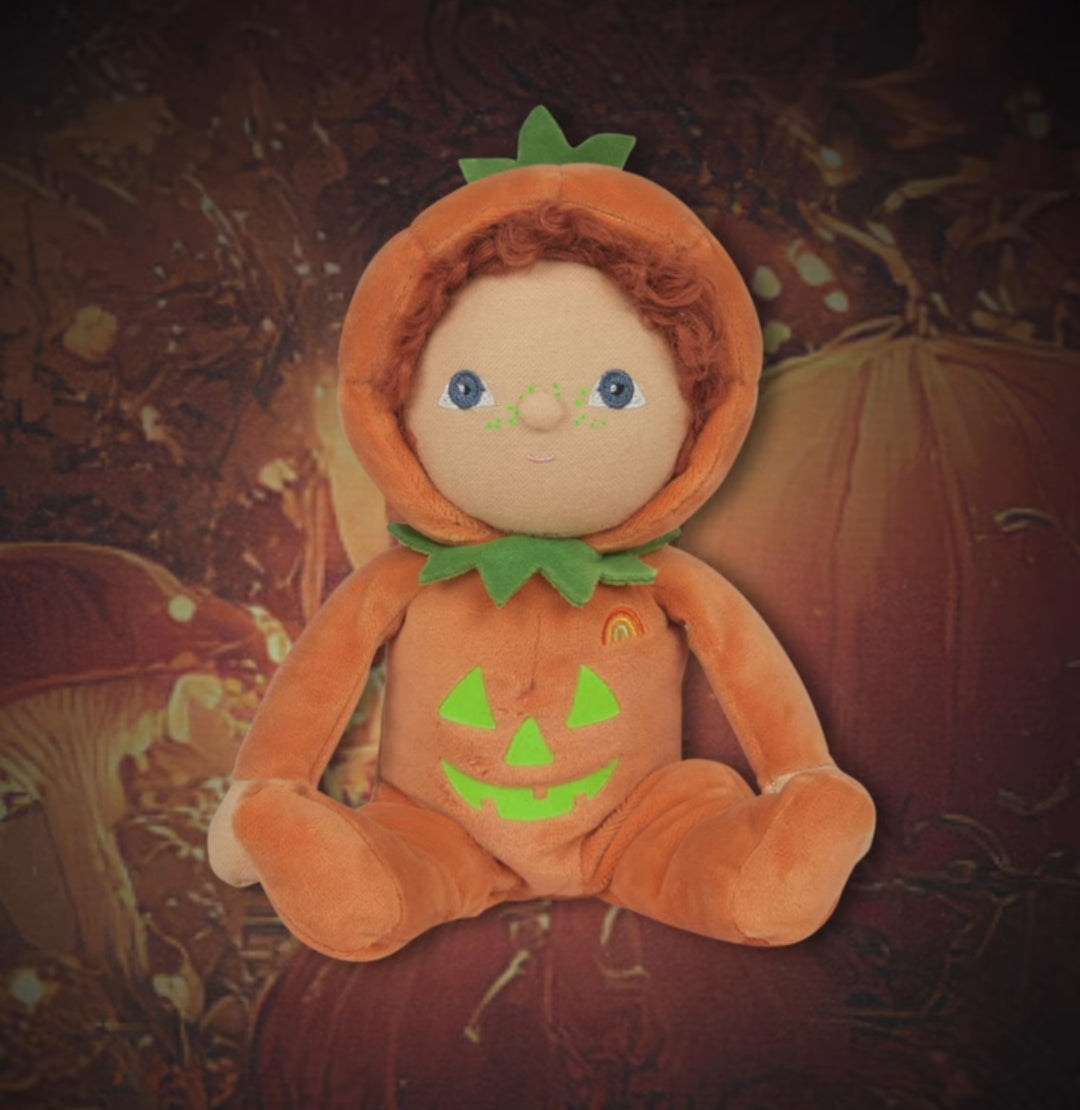 Plush toy dressed as a pumpkin with glowing eyes on a Halloween-themed background