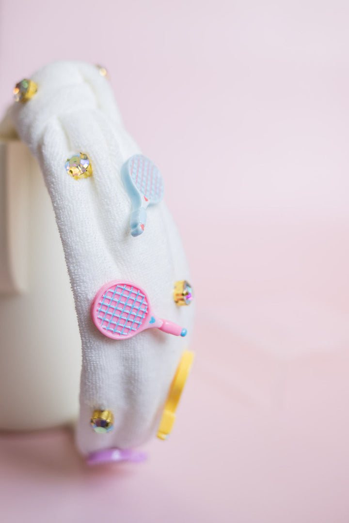 White top knot headband with colorful tennis raquet charms designs on a pink background