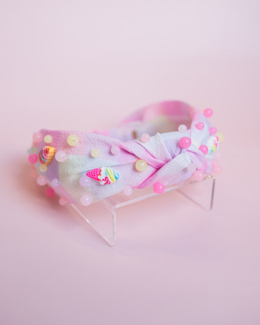 Pastel-colored headband with ice cream charms and small decorations on a pink background