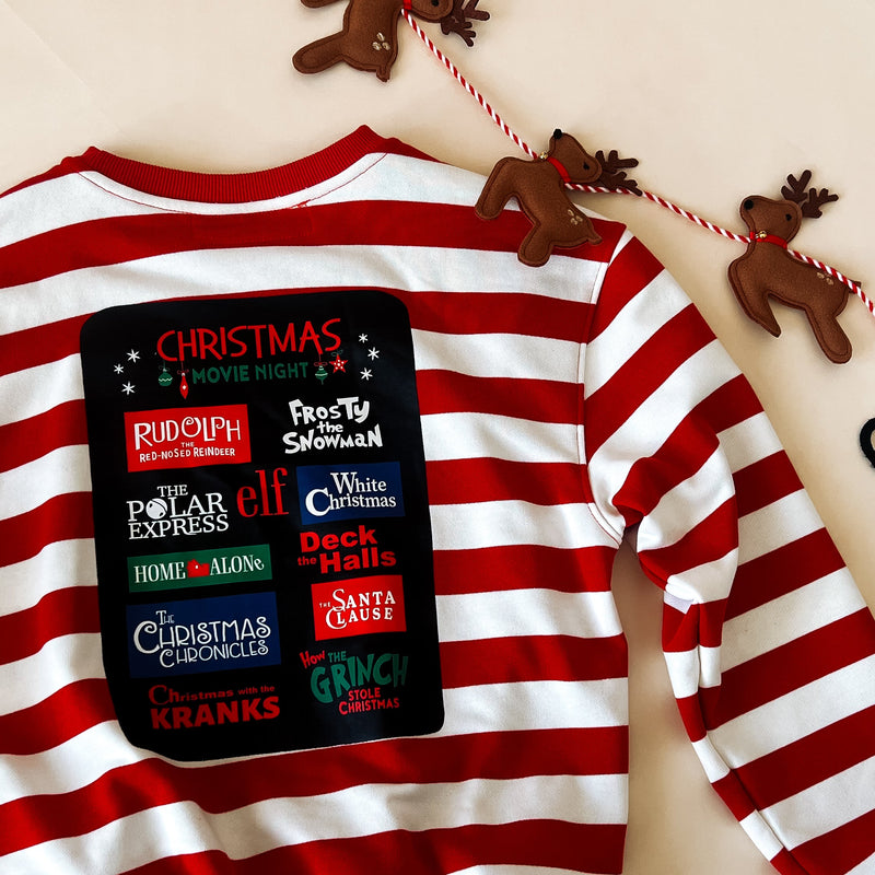 the back of the sweatshirt with all of the big Holiday movies printed: Rudolph the red nose reindeer, polar express, home alone, the grinch, white christmas