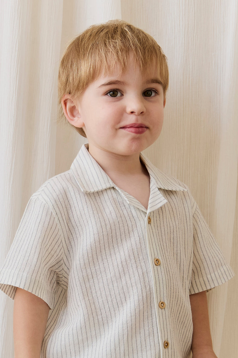 Young boy wearing a striped shirt against a neutral background