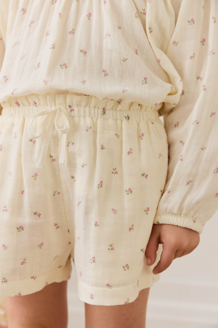 Cream-colored pajama set with floral pattern on a plain background