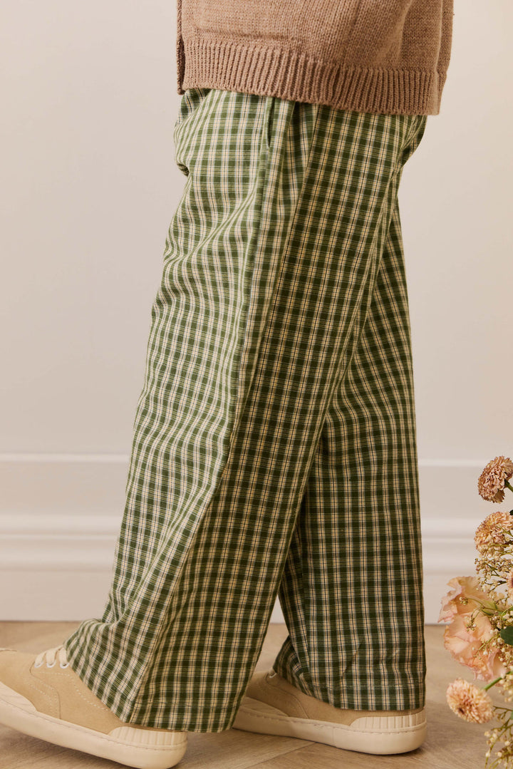 Green checkered pants worn by a person with a neutral background