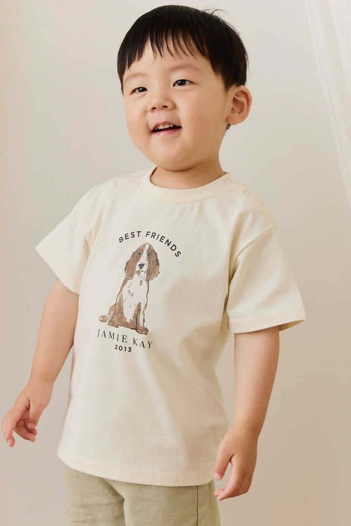 Child wearing a cream t-shirt with a dog graphic and text on a beige background